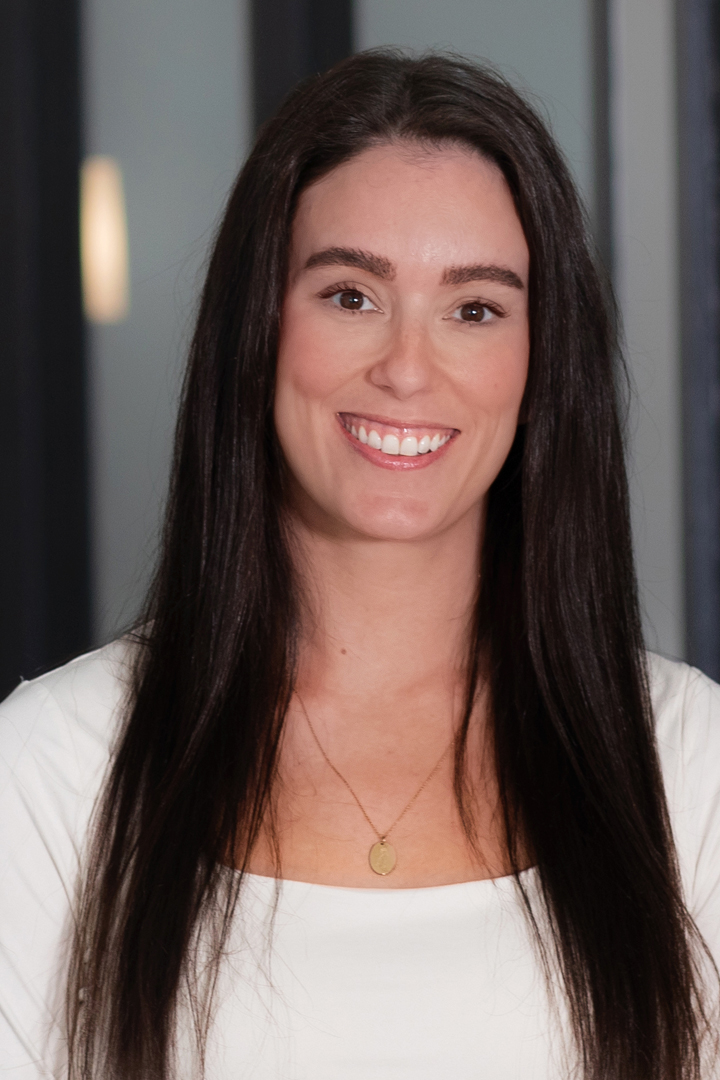 Headshot of Brittany Seidman smiling with long and straight dark hair and white top